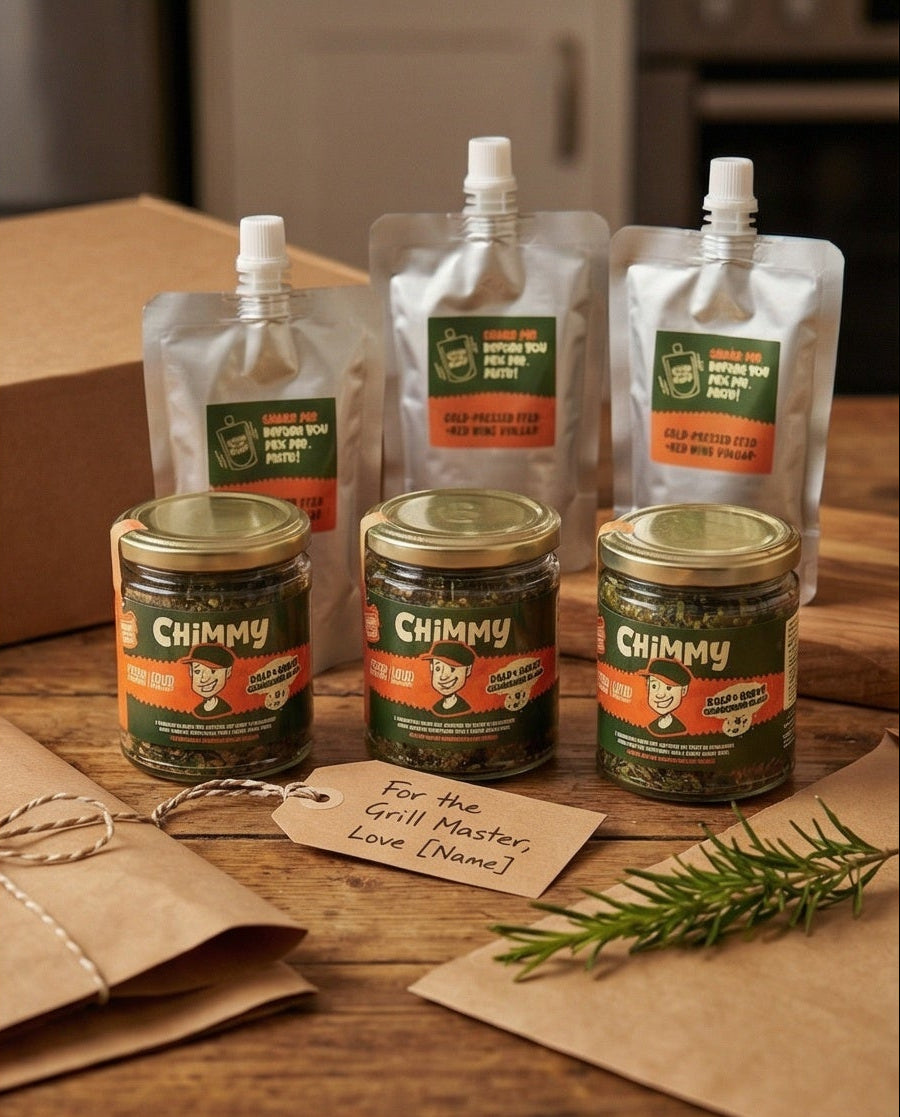 Three Chimmy chimichurri kits — herb jars and vinegar pouches — arranged with a gift tag reading For the Grill Master and a sprig of rosemary